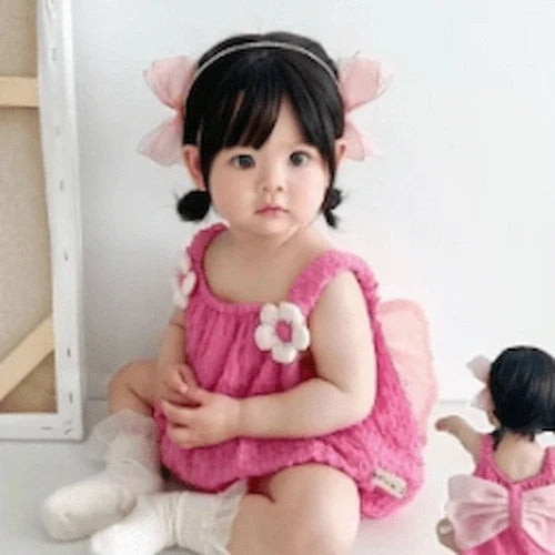 baby girl sitting on floor wearing pink dress