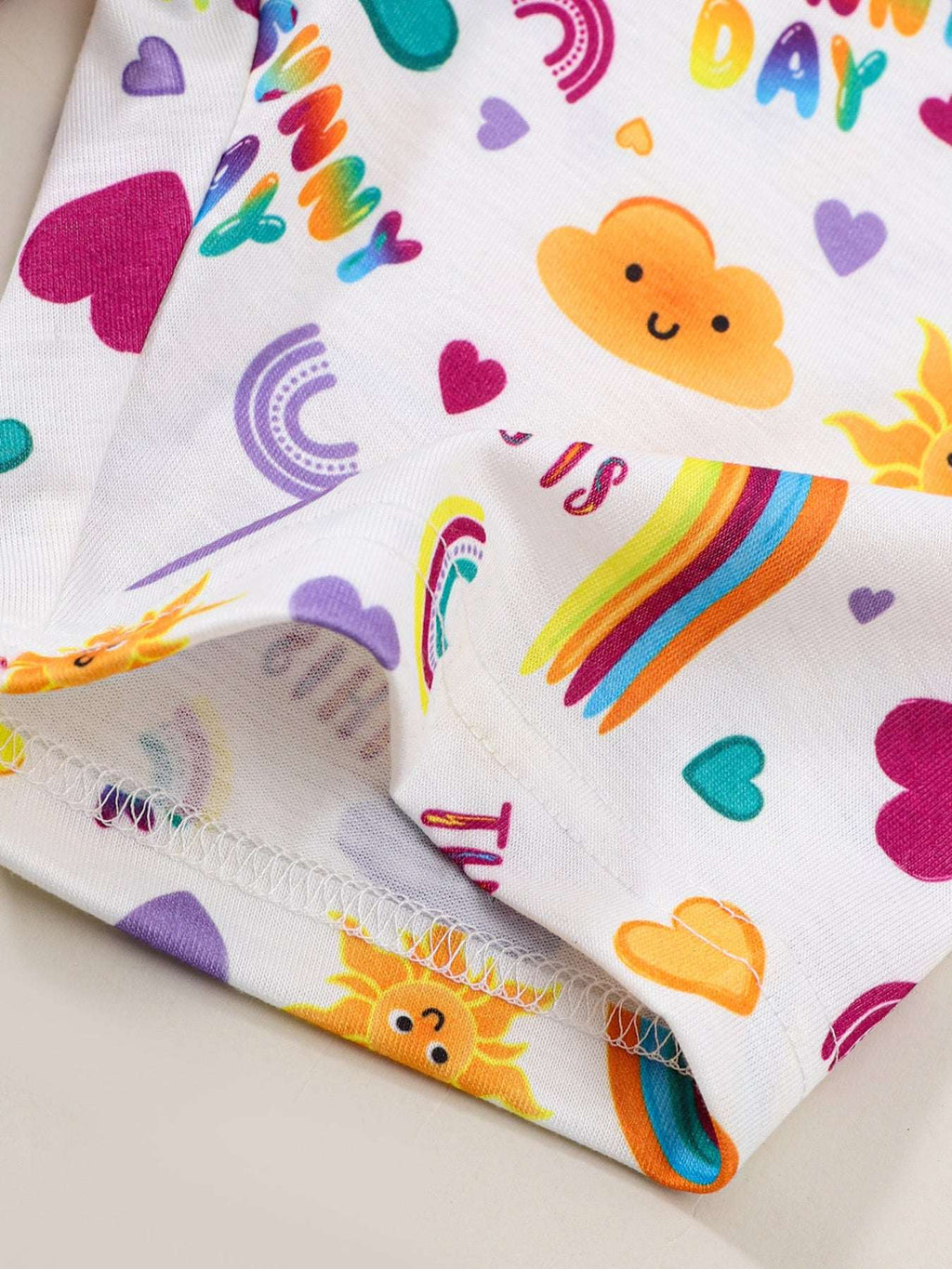 Kids white shorts with colorful rainbow, hearts, and animal motifs, stitched hem