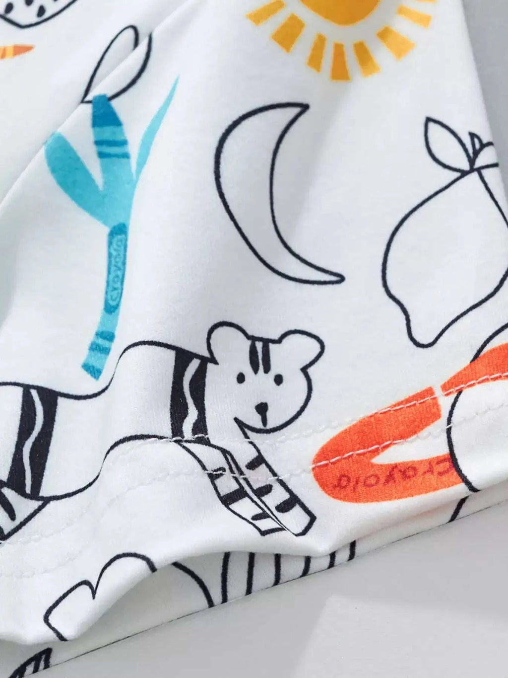 Kids cartoon print fabric close-up with dog, moon, stars and crayon shapes on white