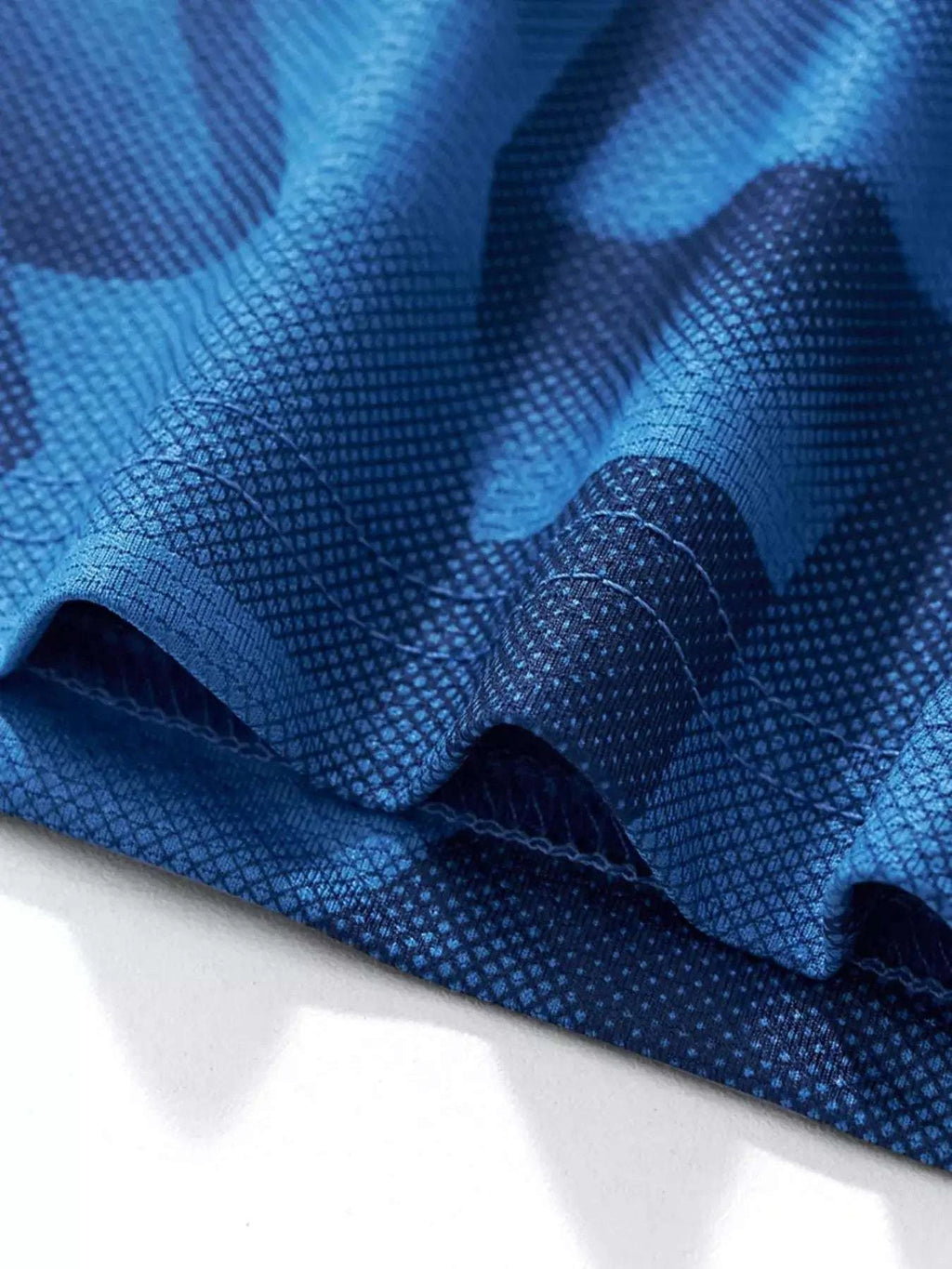 Dark blue quick-dry sport set fabric closeup with geometric pattern and stitching