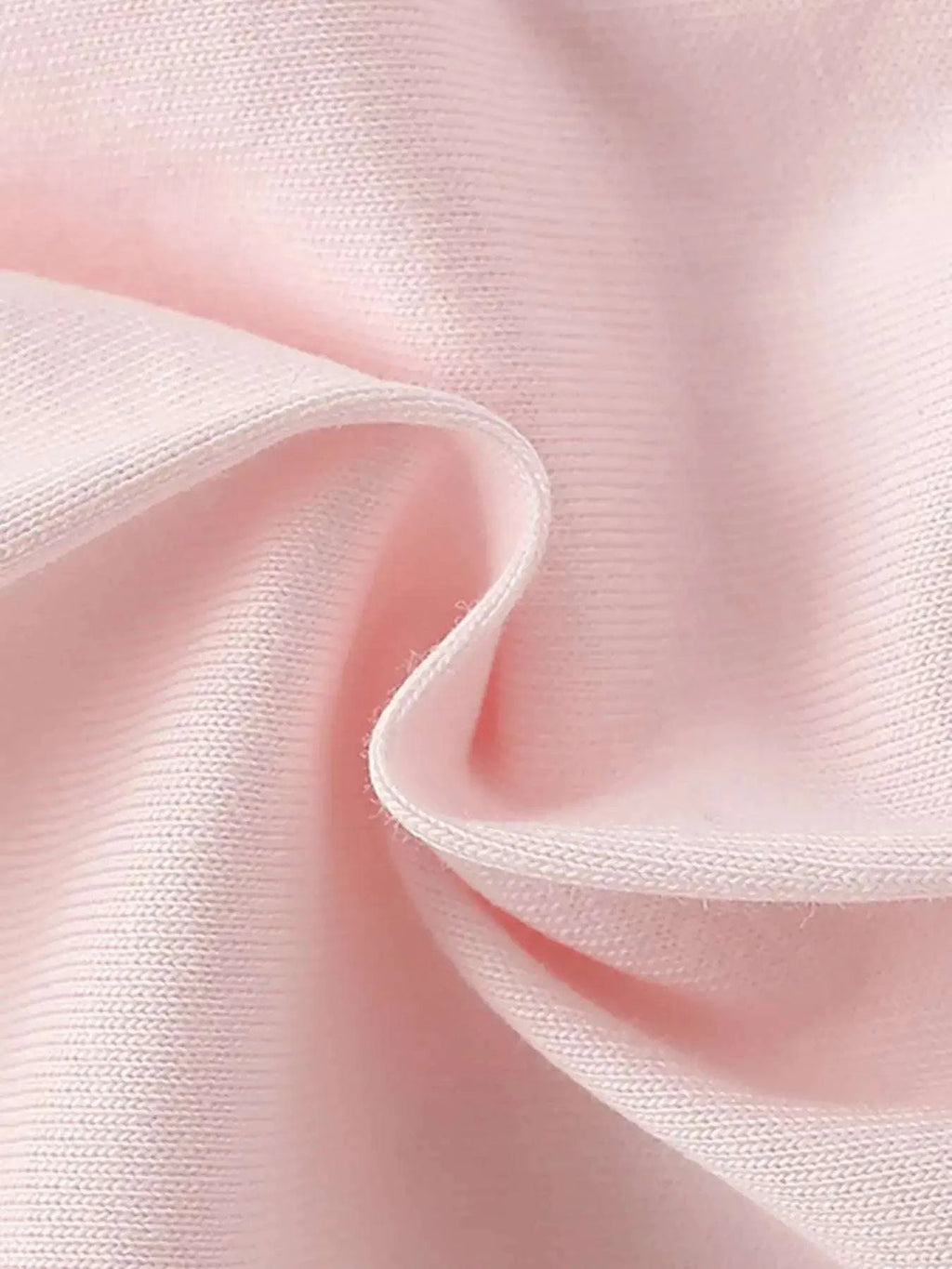 Light pink knit fabric close-up with stitched edge and soft texture