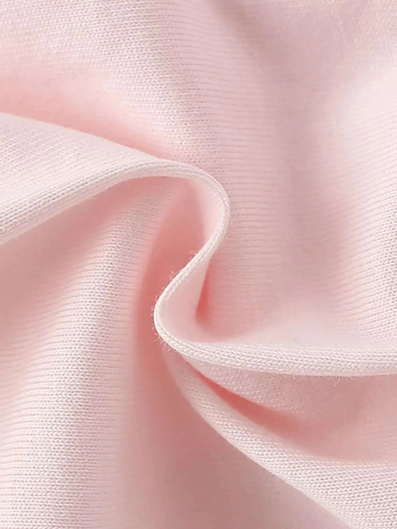 Light pink knit fabric close-up with stitched edge and soft texture