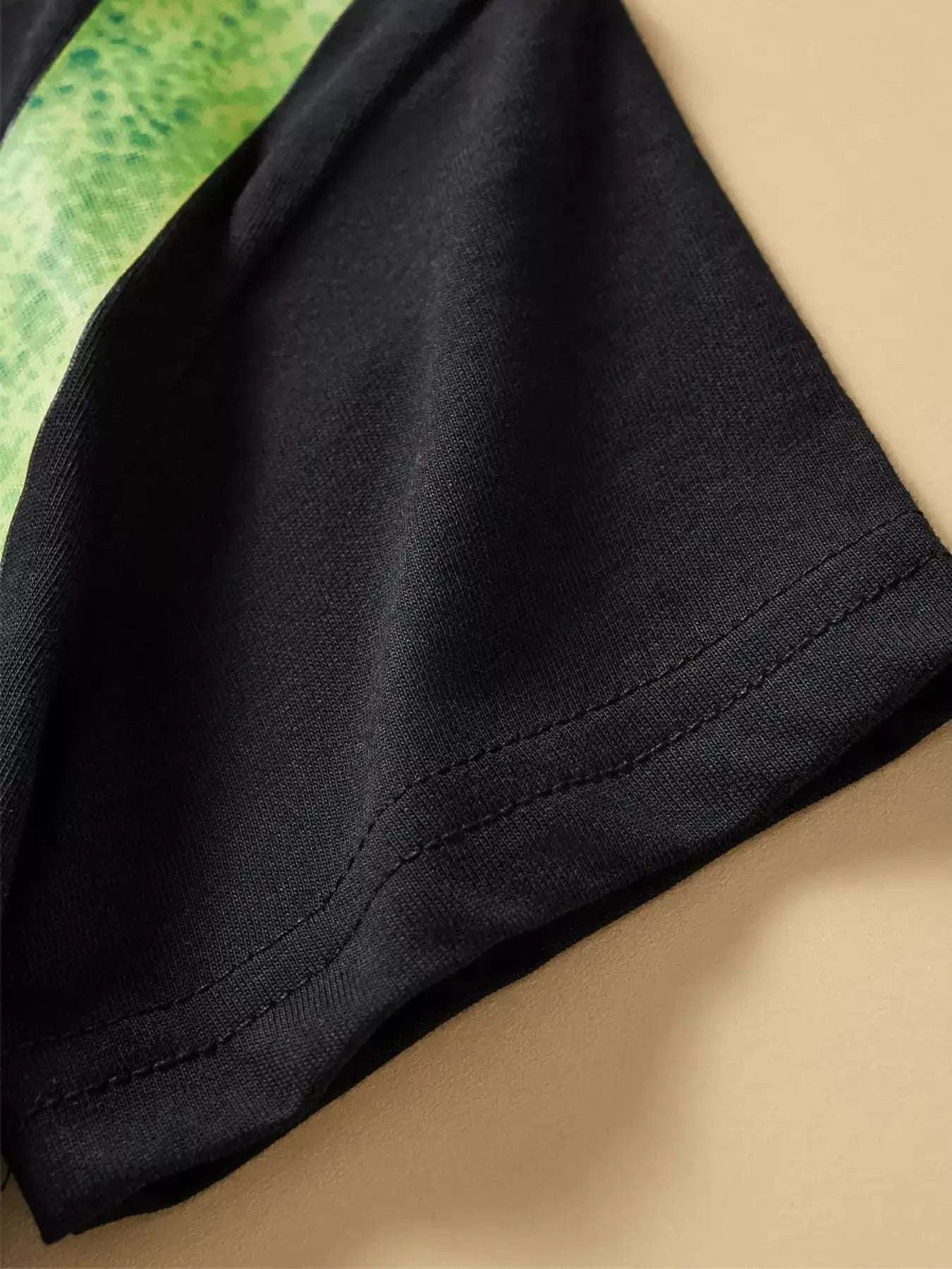 Black children's dino pizza graphic tee fabric and side seam close-up