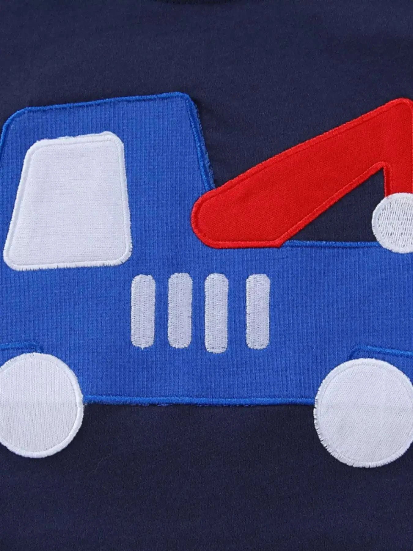 Dark navy kids T-shirt with blue truck graphic, white wheels, and red accents