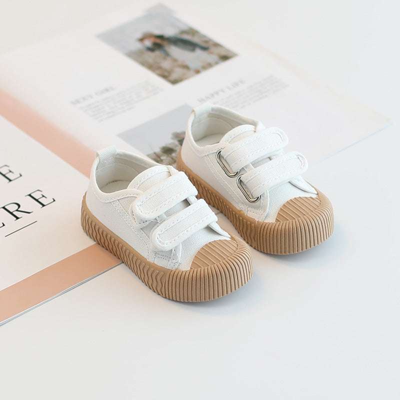 Baby canvas sneakers with hook-and-loop straps, white uppers and tan ribbed sole