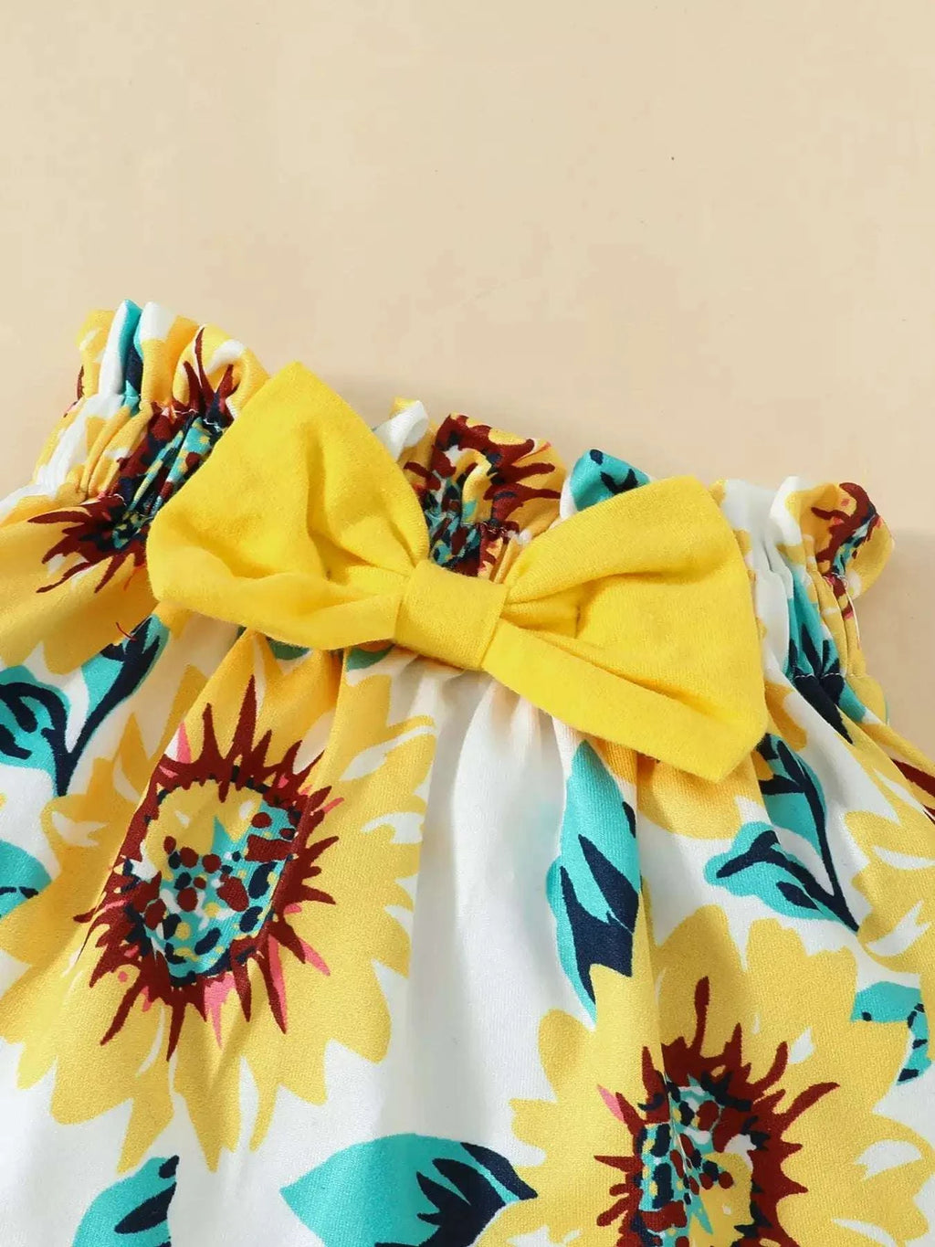 Sunflower print skirt with ruffled hem and large yellow bow headband
