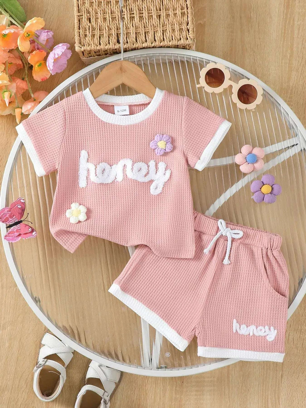 Pink waffle-knit kids tee and shorts set with honey text and small flower details