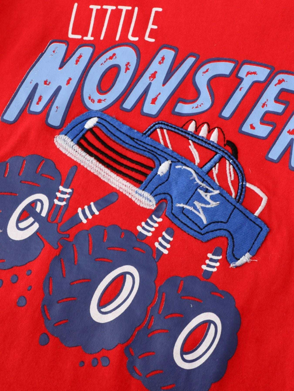 Red tee featuring monster graphic with blue and white lettering