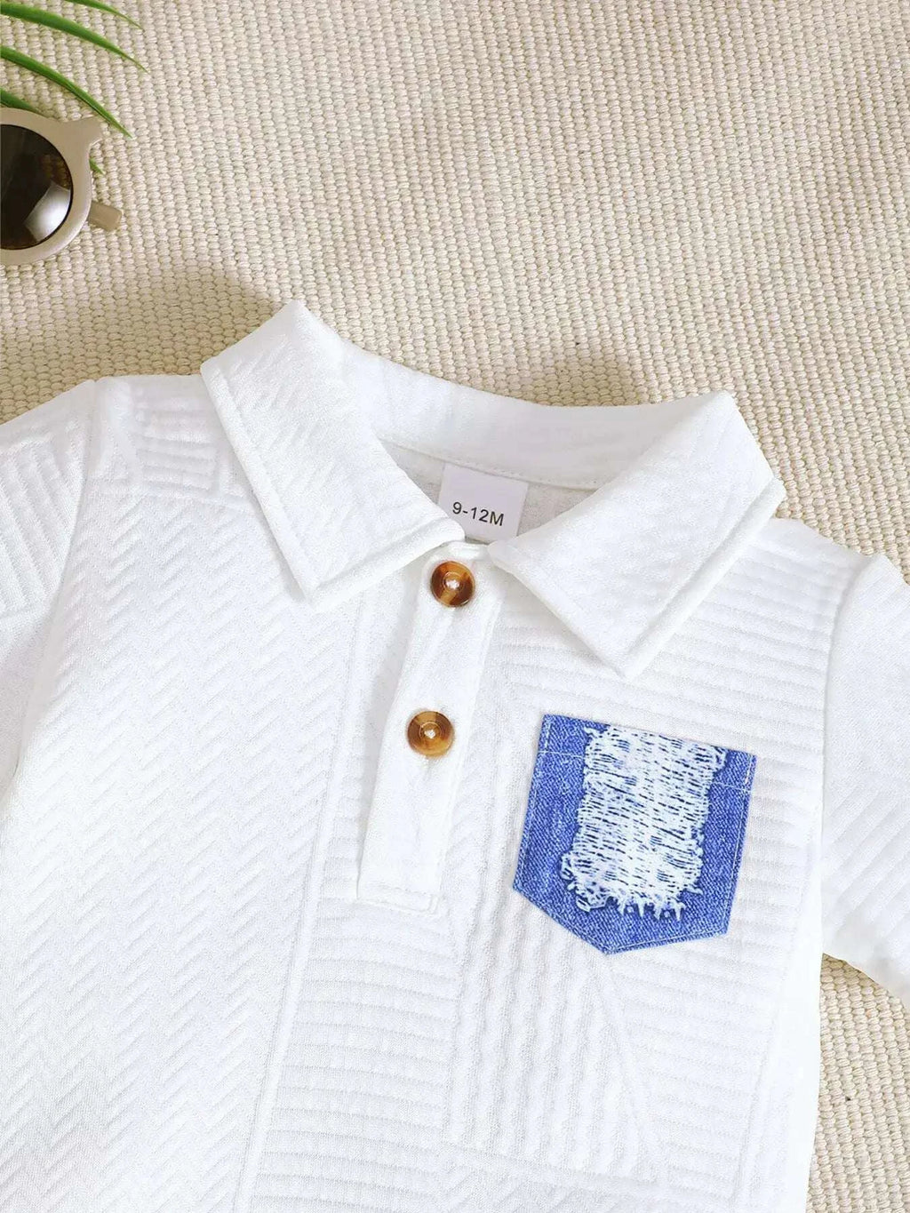 White textured polo shirt with blue patch pocket and wooden button placket