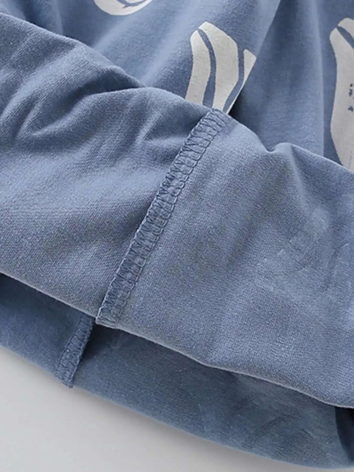 Dusty blue kids tee sleeve with stitched cuff and ocean wave graphic