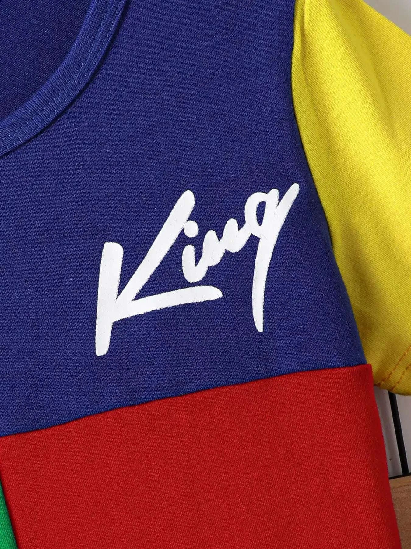 White cursive graphic logo on navy-blue tee with red panel below