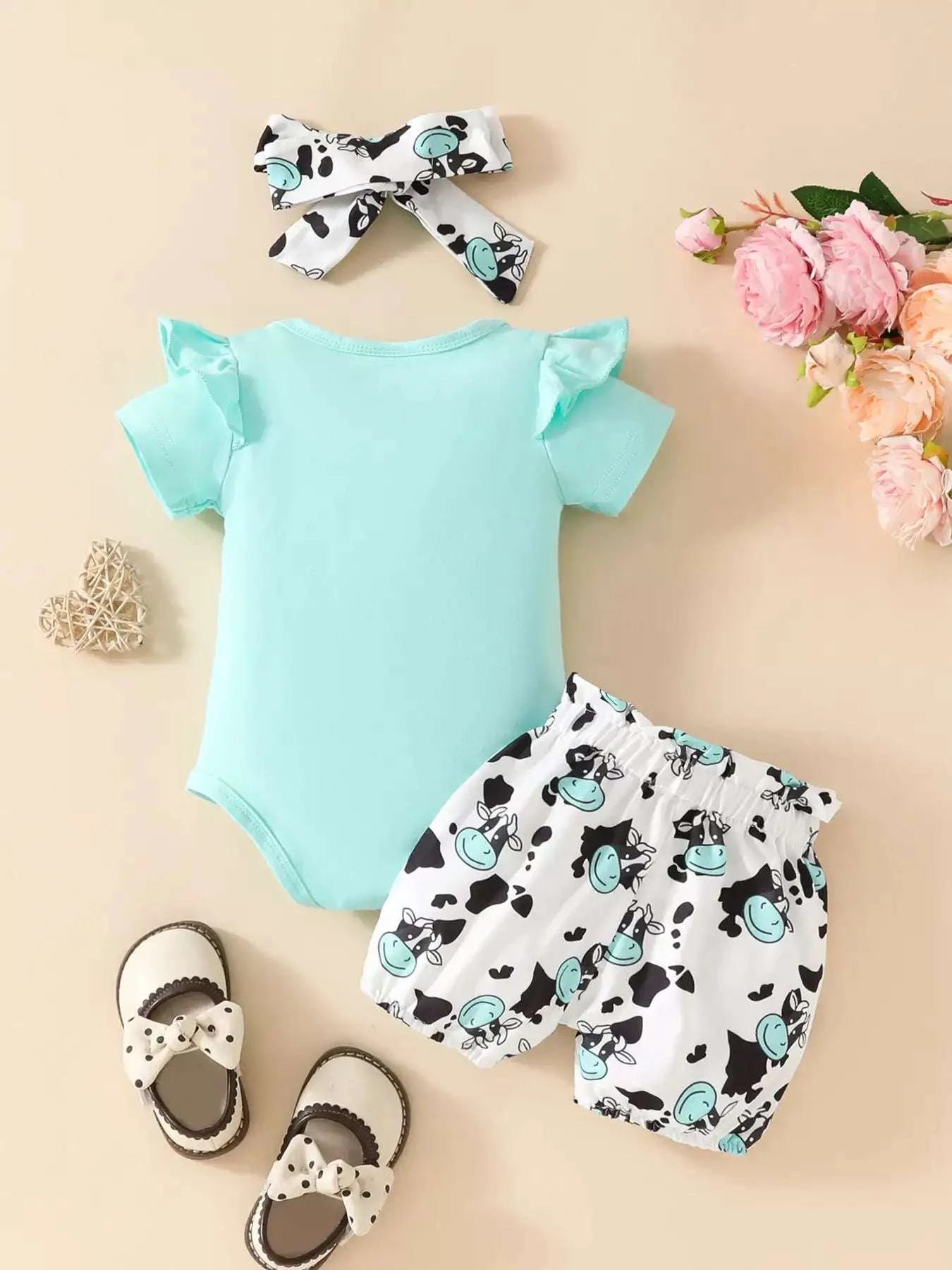 Light blue ruffled cow bodysuit, cow-print shorts, and white bow headband set
