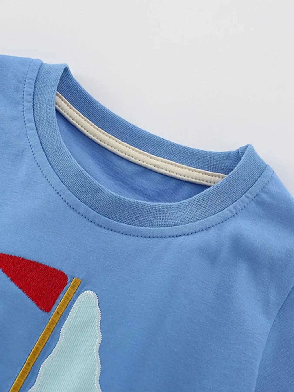 Sky blue kids tee with ribbed crew neck and partial sailboat graphic