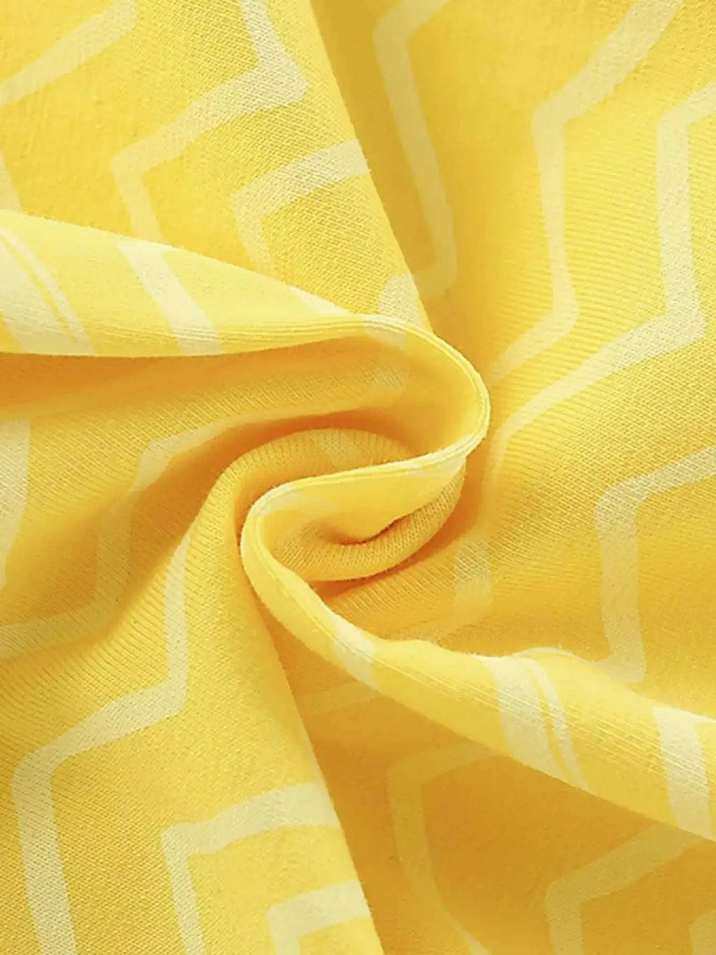 Yellow zigzag-pattern fabric closeup with soft, crinkle-like drape