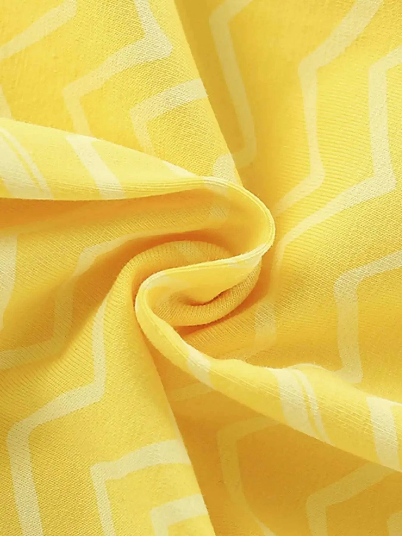 Yellow zigzag-pattern fabric closeup with soft, crinkle-like drape