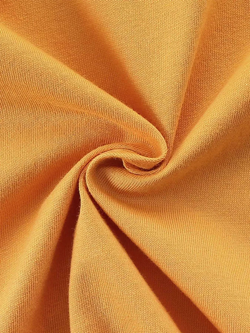 Children's gold t-shirt fabric close-up with soft drape texture