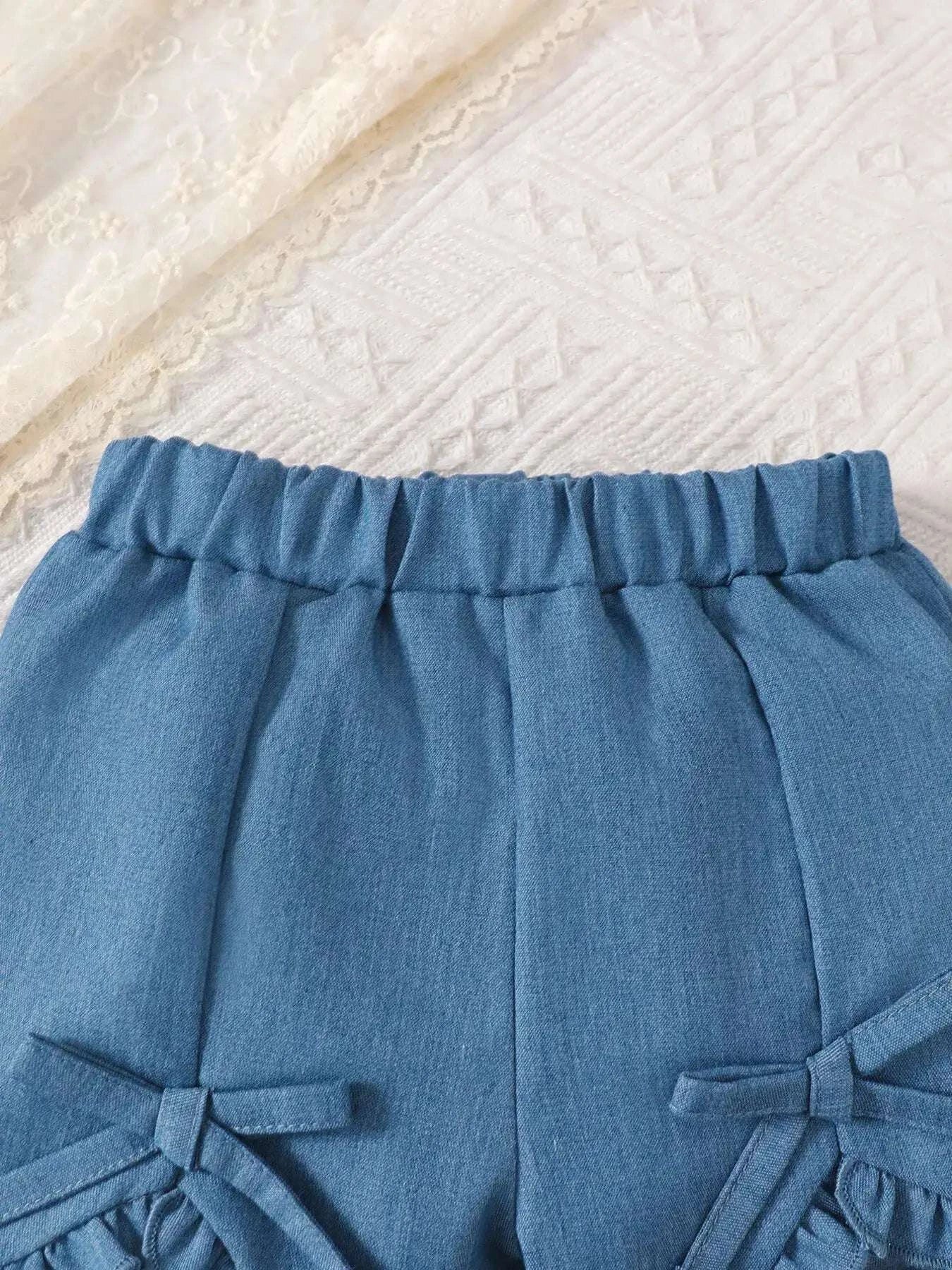 Blue ruffled waist shorts with bow accents at side seams
