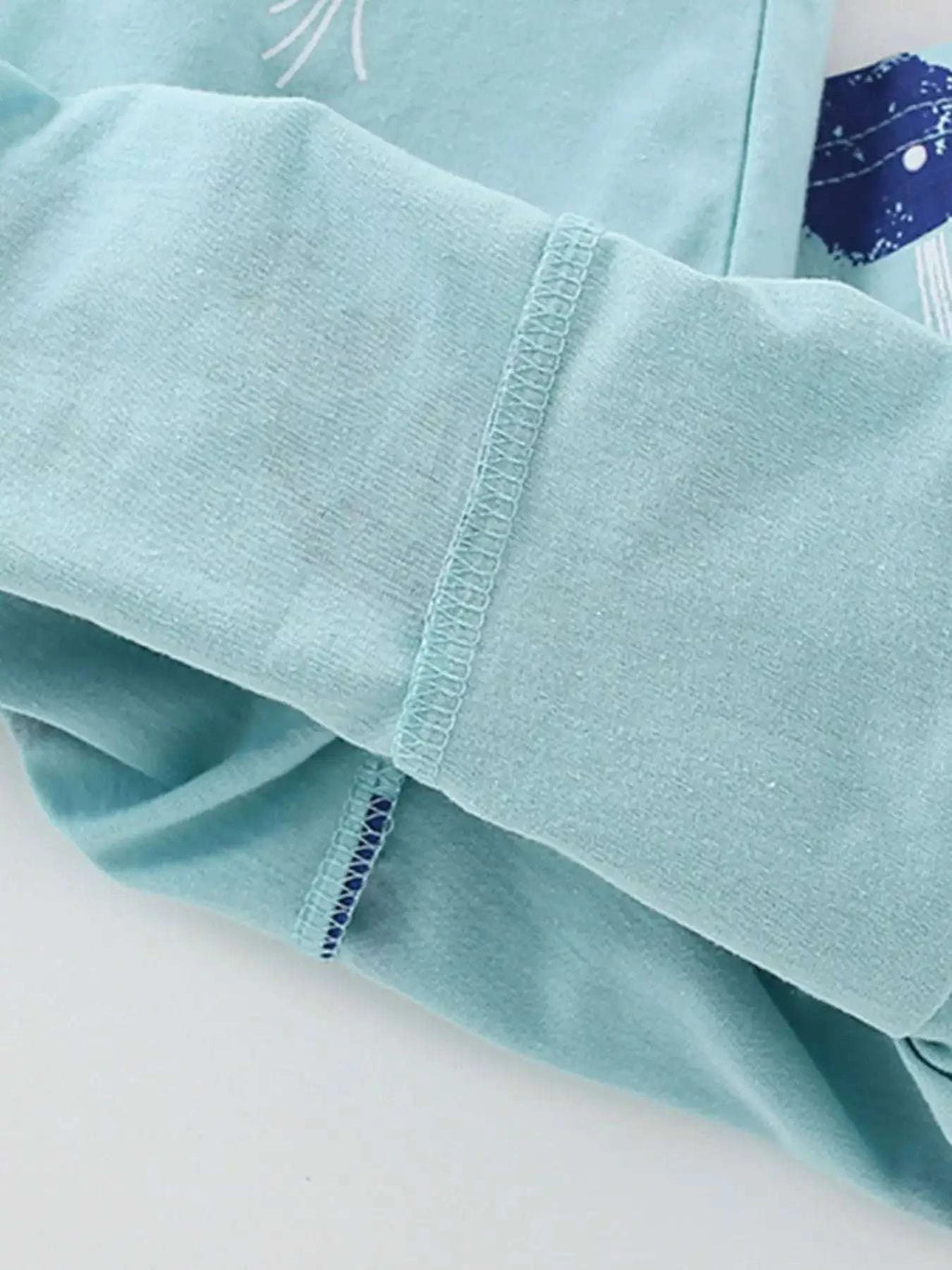 Light blue T-shirt sleeve cuff with contrast stitching and navy inner trim
