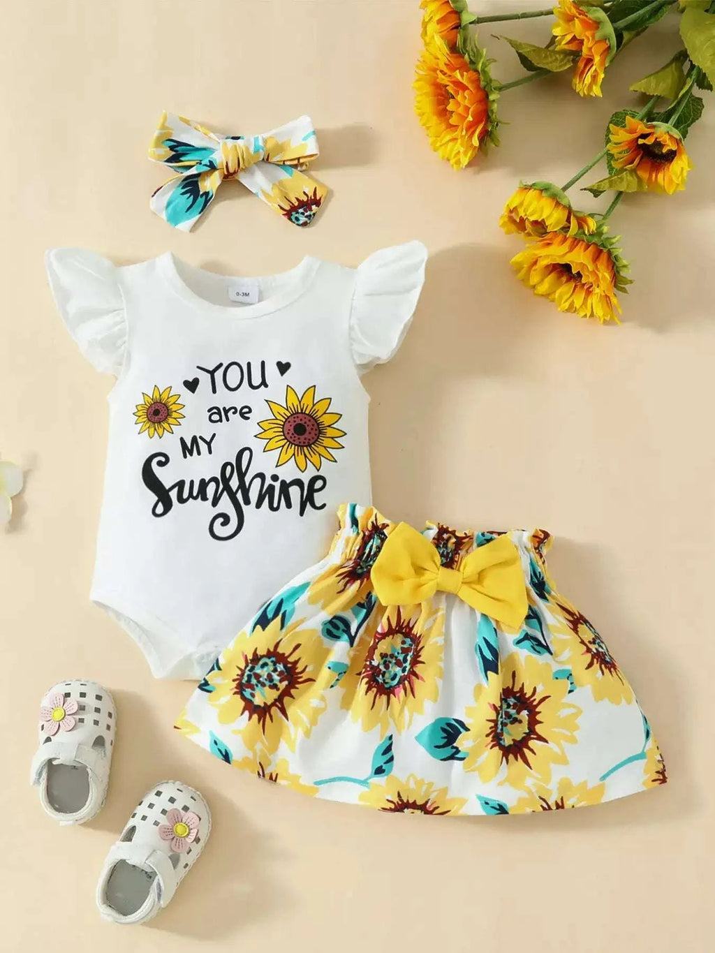Children's off-white ruffled bodysuit with sunflower skirt set and bow headband