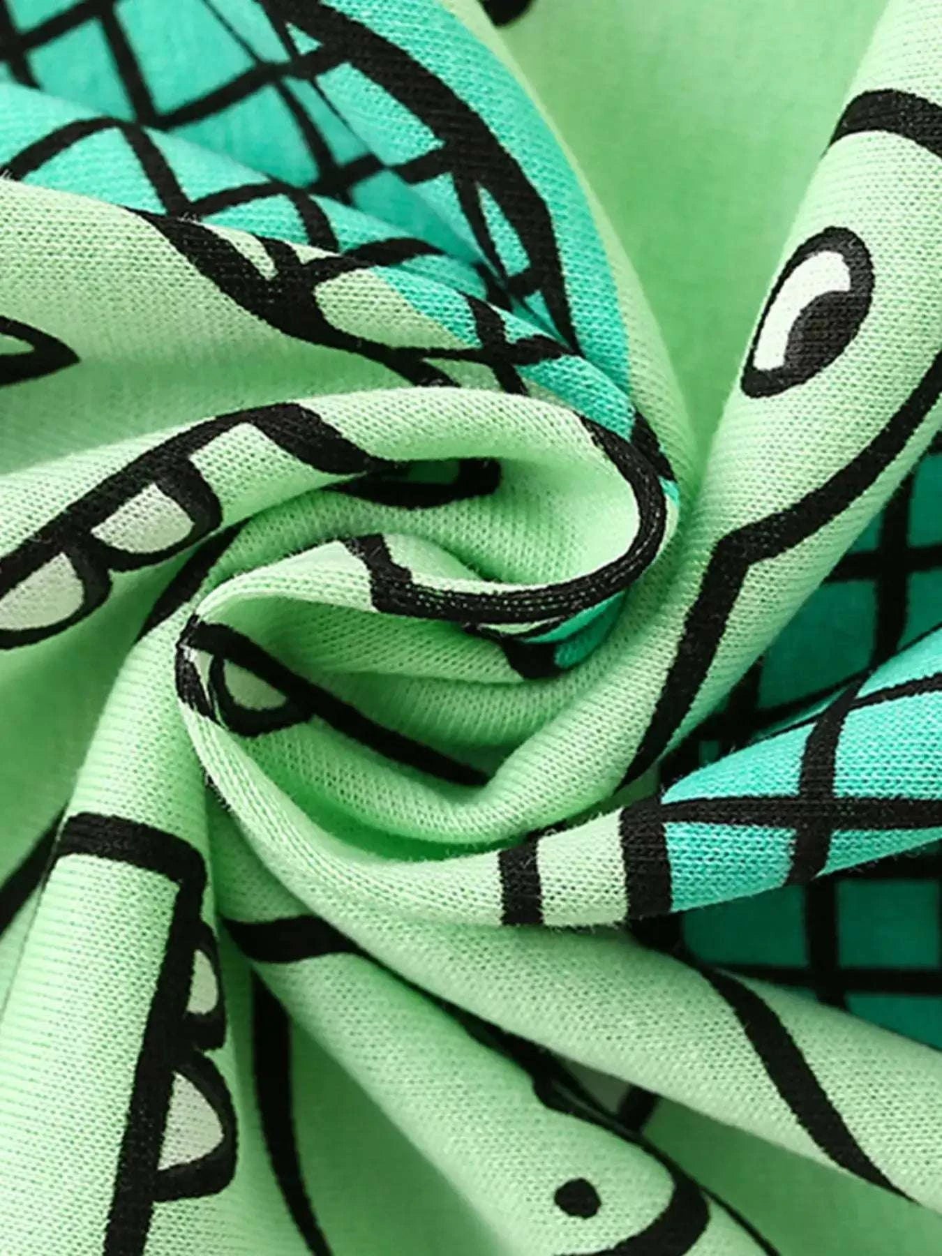 Mint green fabric close-up with black crocodile scale print texture