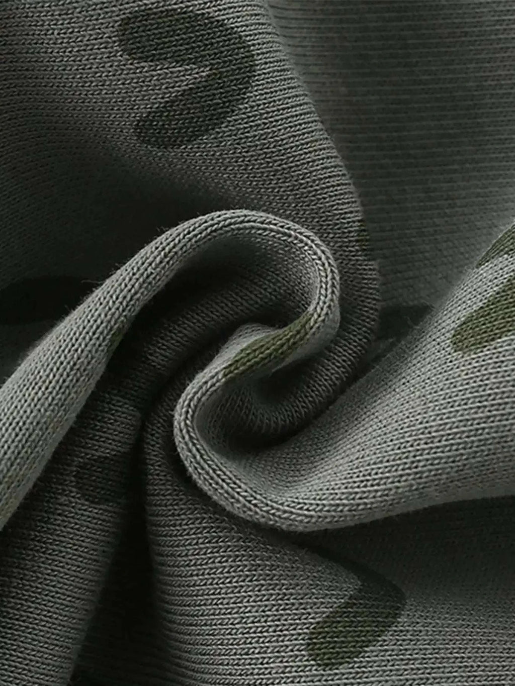 Gray-green cotton shorts fabric close-up with crocodile pattern texture
