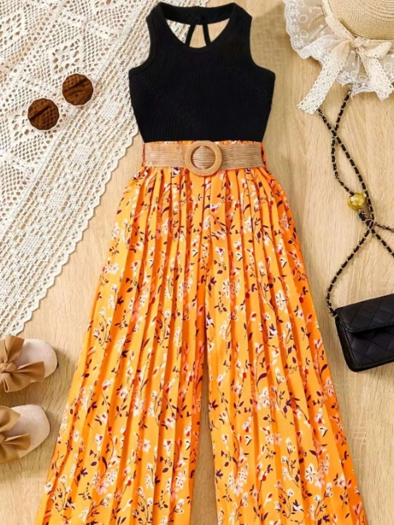 Black sleeveless top with orange patterned wide-leg skirt and woven belt with round ring