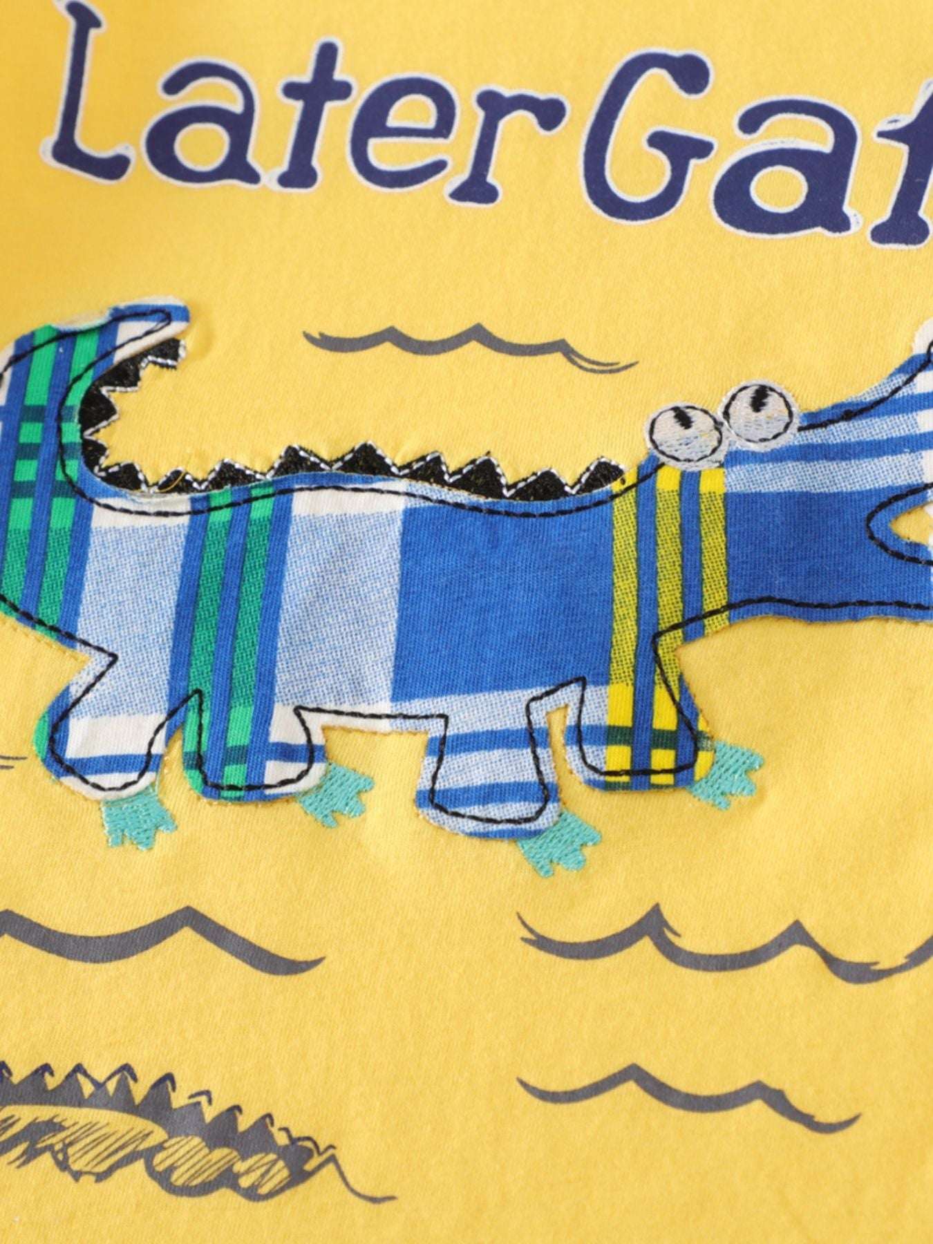 Yellow tee featuring gator graphic with blue outline and text
