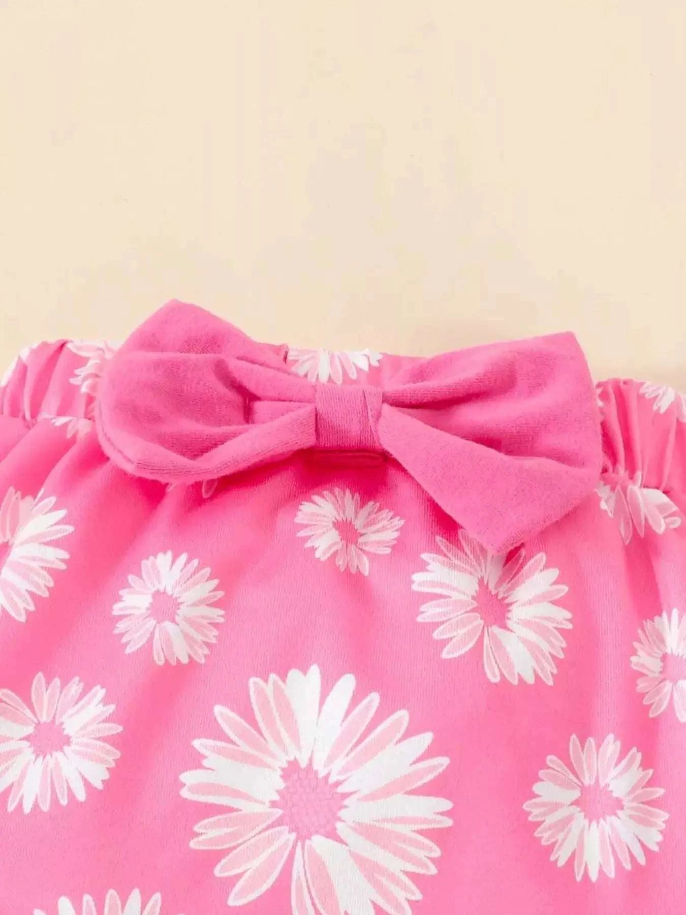 Children's fuchsia pink daisy-print top with large bow at neckline