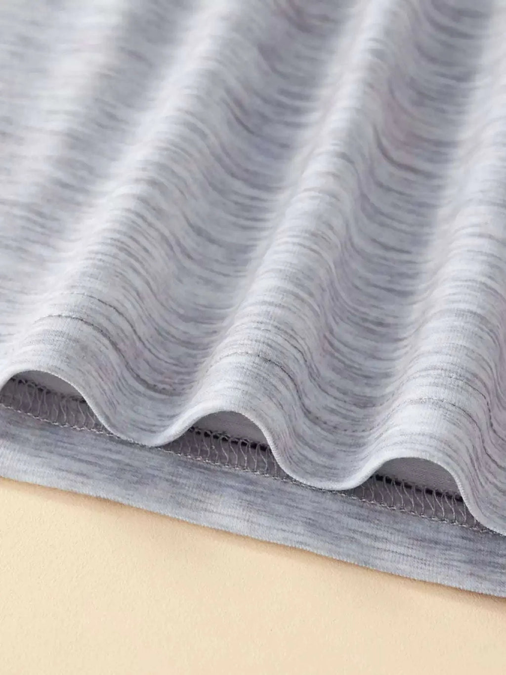Heather gray knit tee fabric texture with stitched hem edge