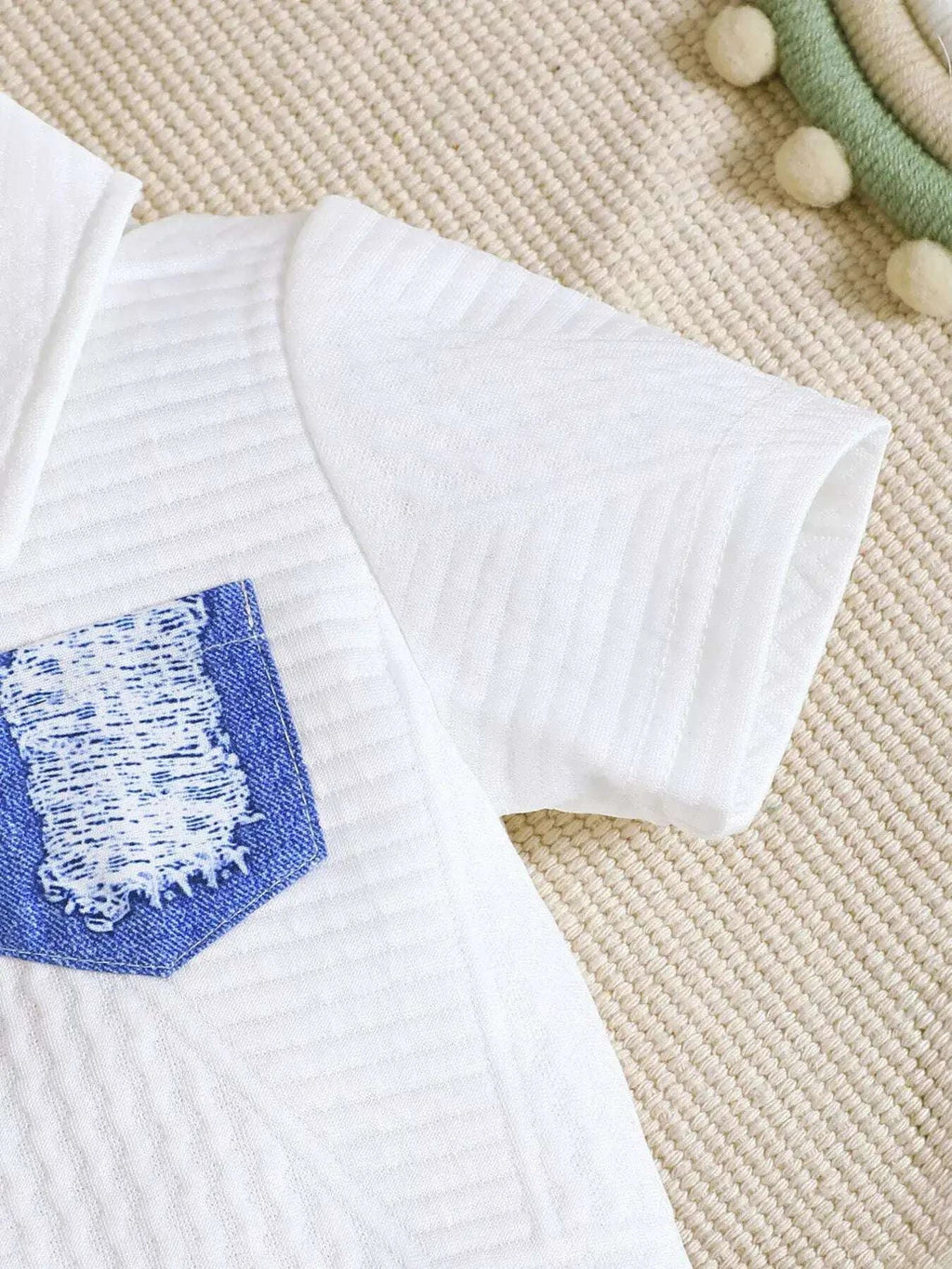 White textured polo shirt sleeve and shoulder with blue chest patch