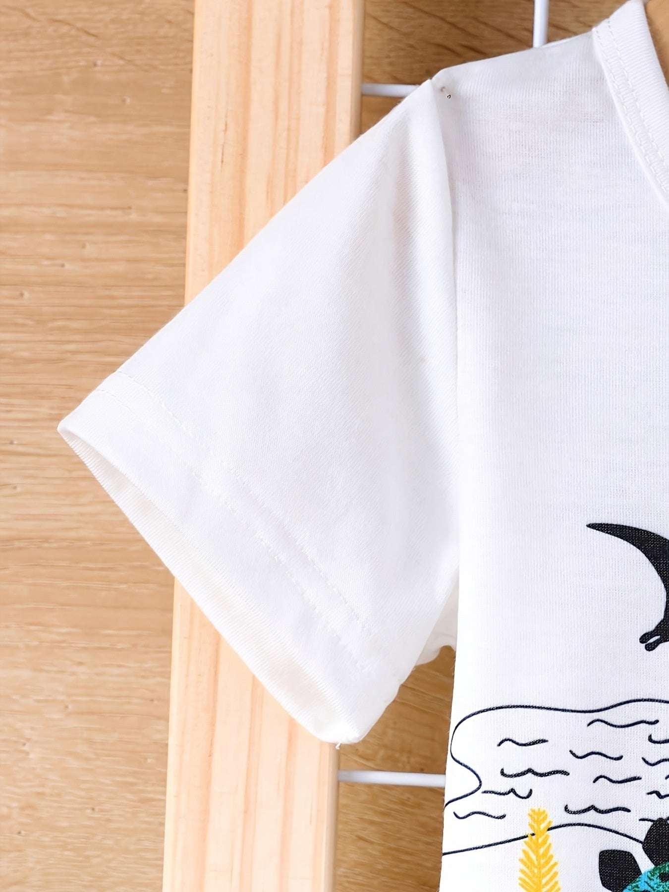 Kids white short sleeve tee with small black dinosaur silhouette print