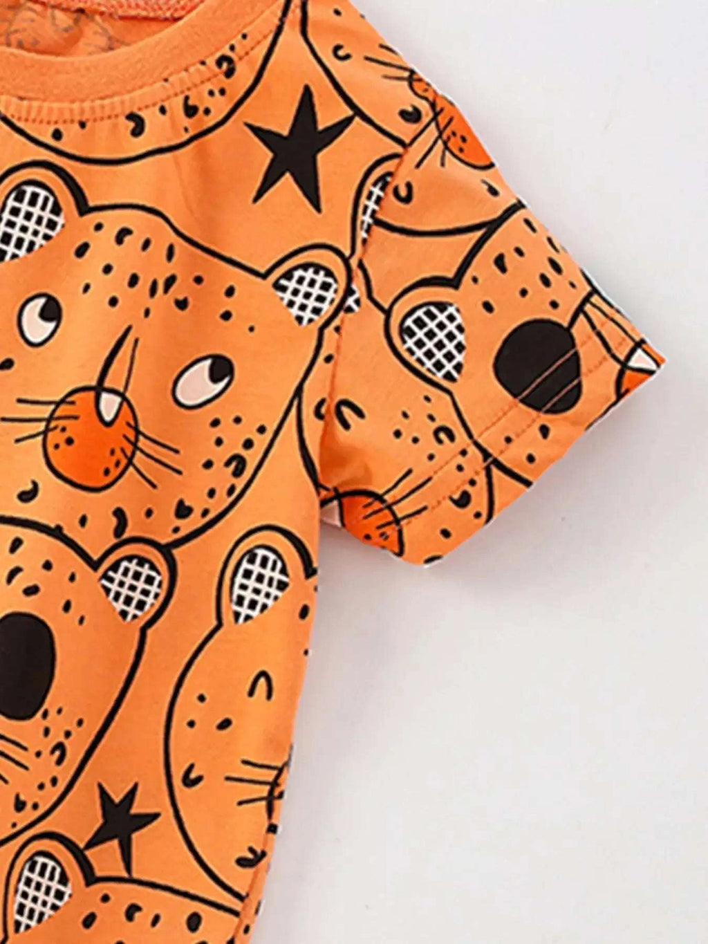 Orange bear-print top sleeve detail with black stars and smiling animal faces