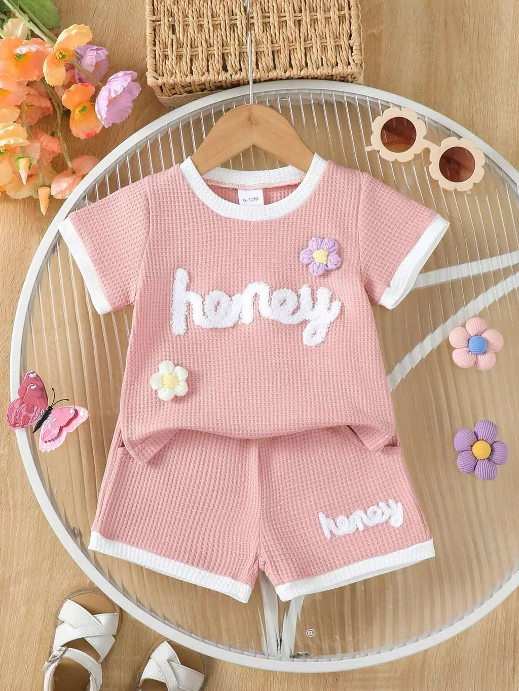 Pink waffle-knit kids tee and shorts set with “honey” print and flower appliques