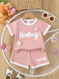 Pink waffle-knit kids tee and shorts set with “honey” print and flower appliques
