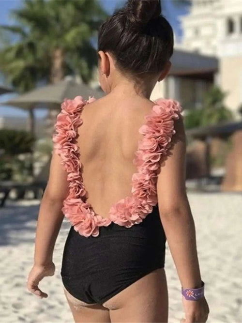 Backless petal strap swimsuit, black one-piece with pink ruffled trim on open back