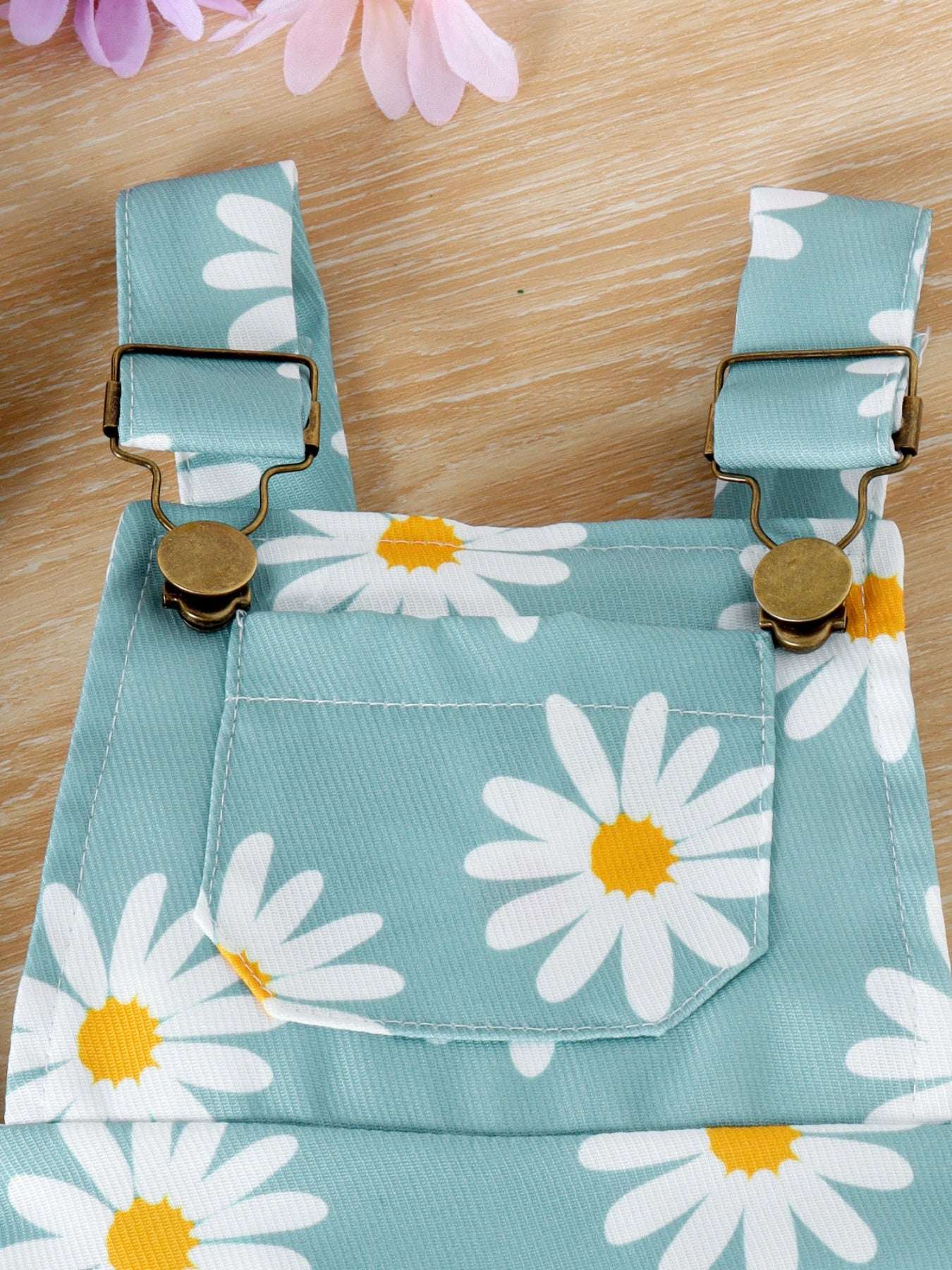 Light blue daisy print overalls with adjustable button suspenders and front pocket