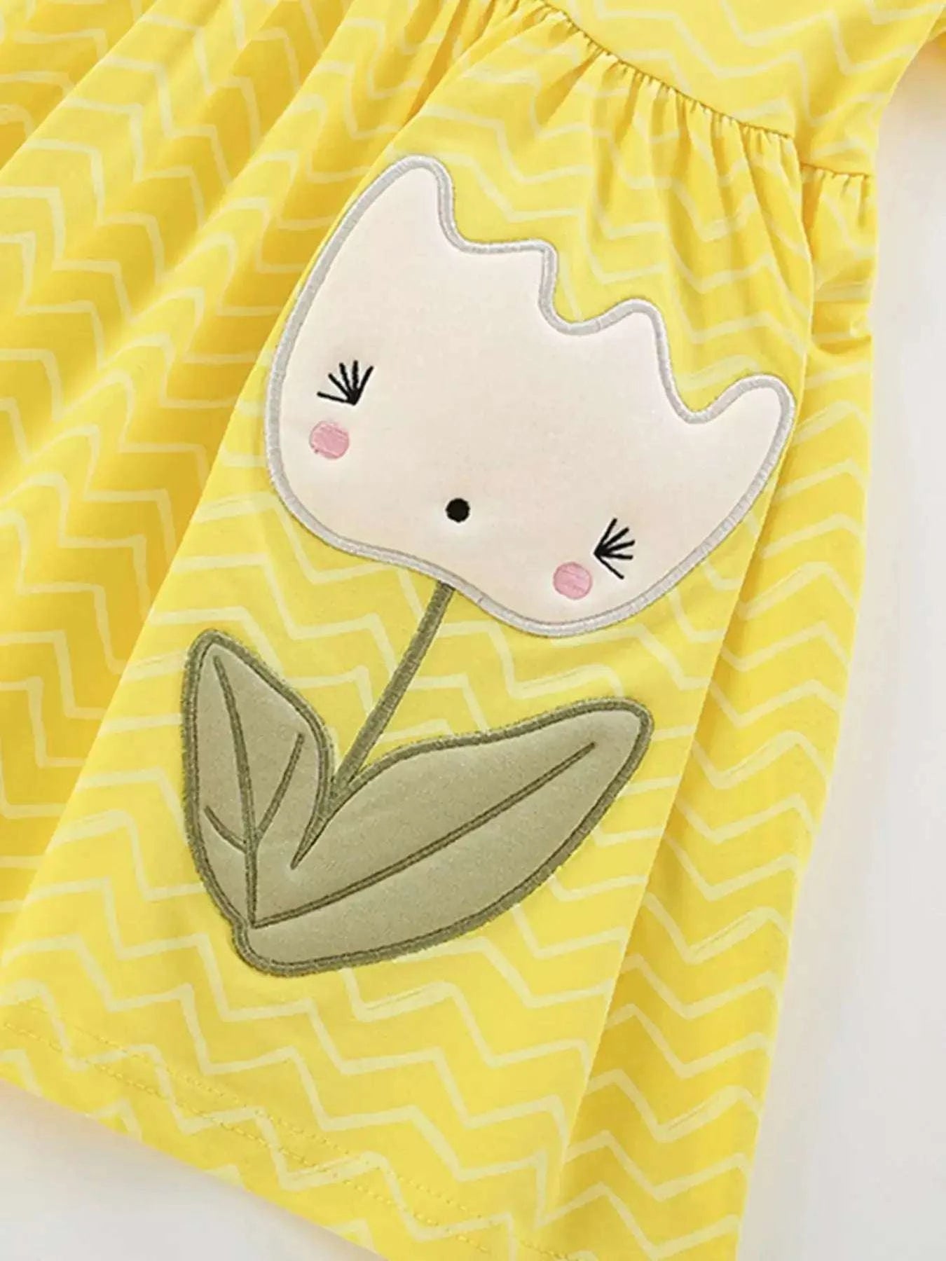 Yellow sleeveless dress with large white bunny-face applique and wavy hem trim
