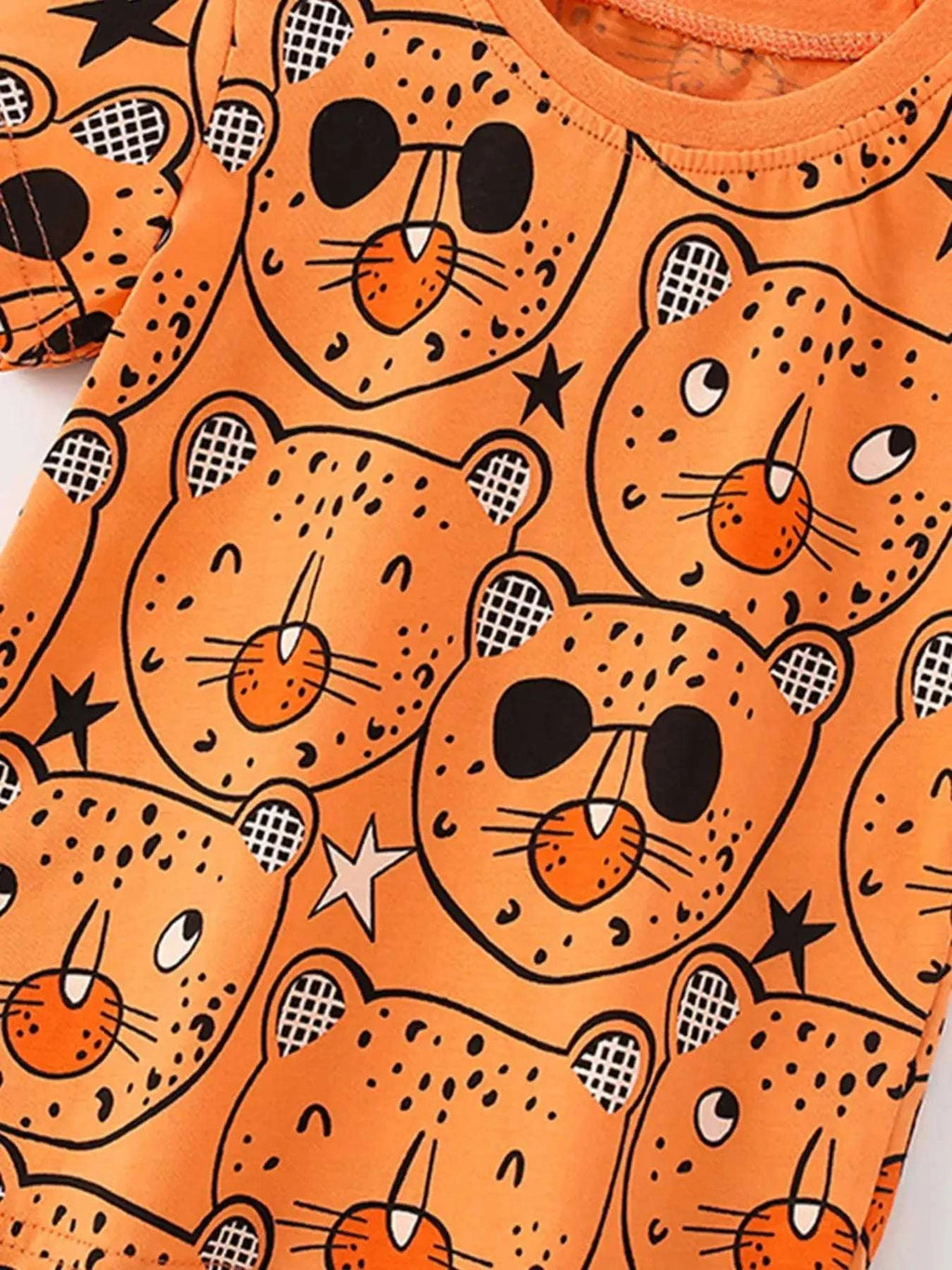 Orange bear-print top with repeating animal faces, black spots, and checkered details