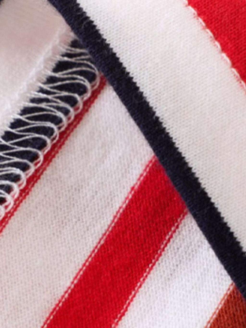 Navy shorts waistband detail with contrasting red stripe and white woven trim