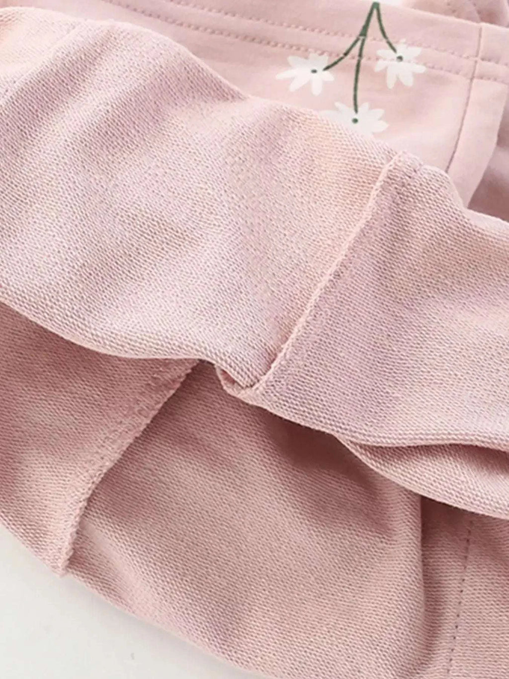 Blush pink kids shorts with elastic waistband; matching knit tee edge visible
