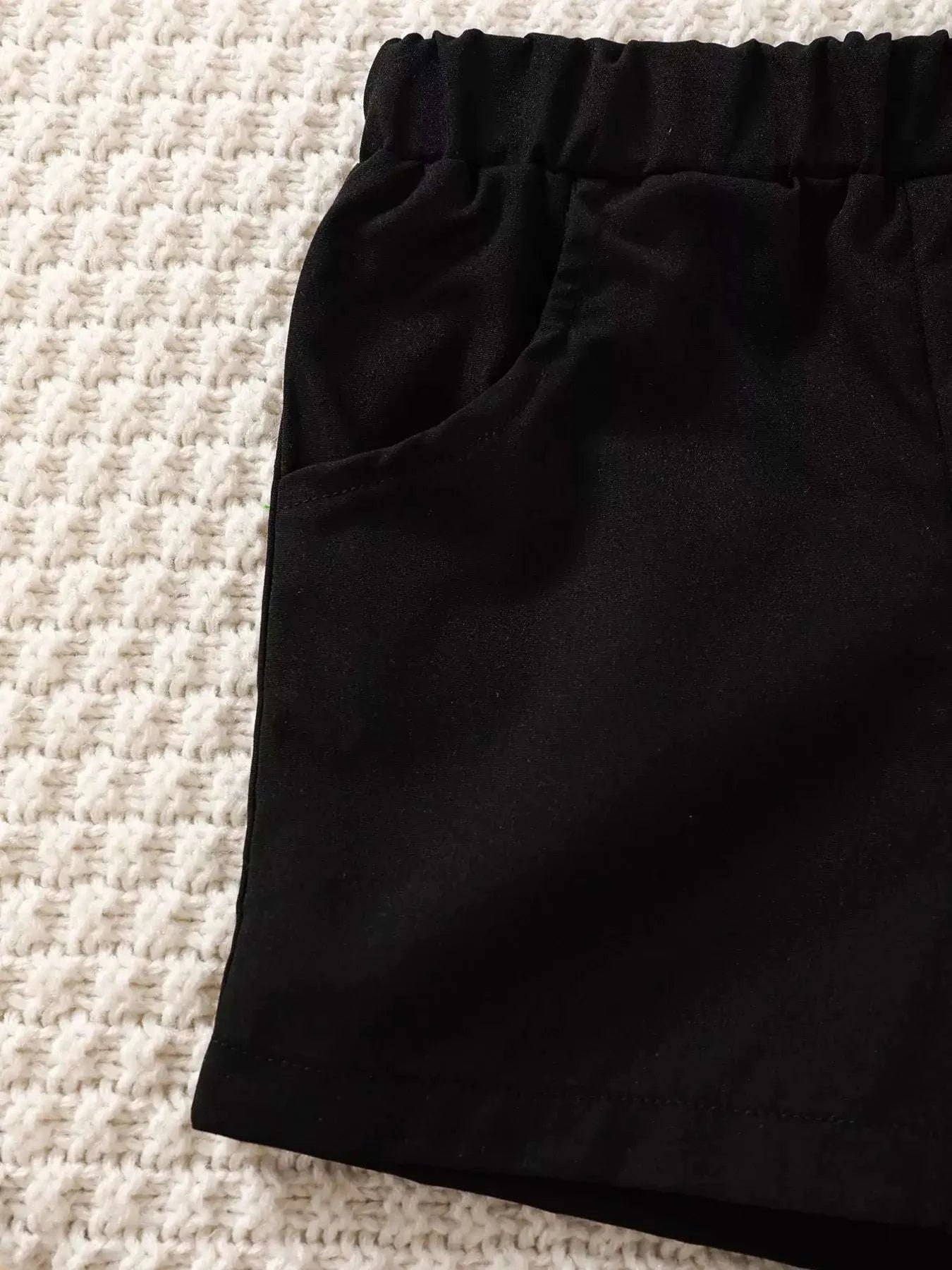 Black shorts fabric with gathered elastic waistband.