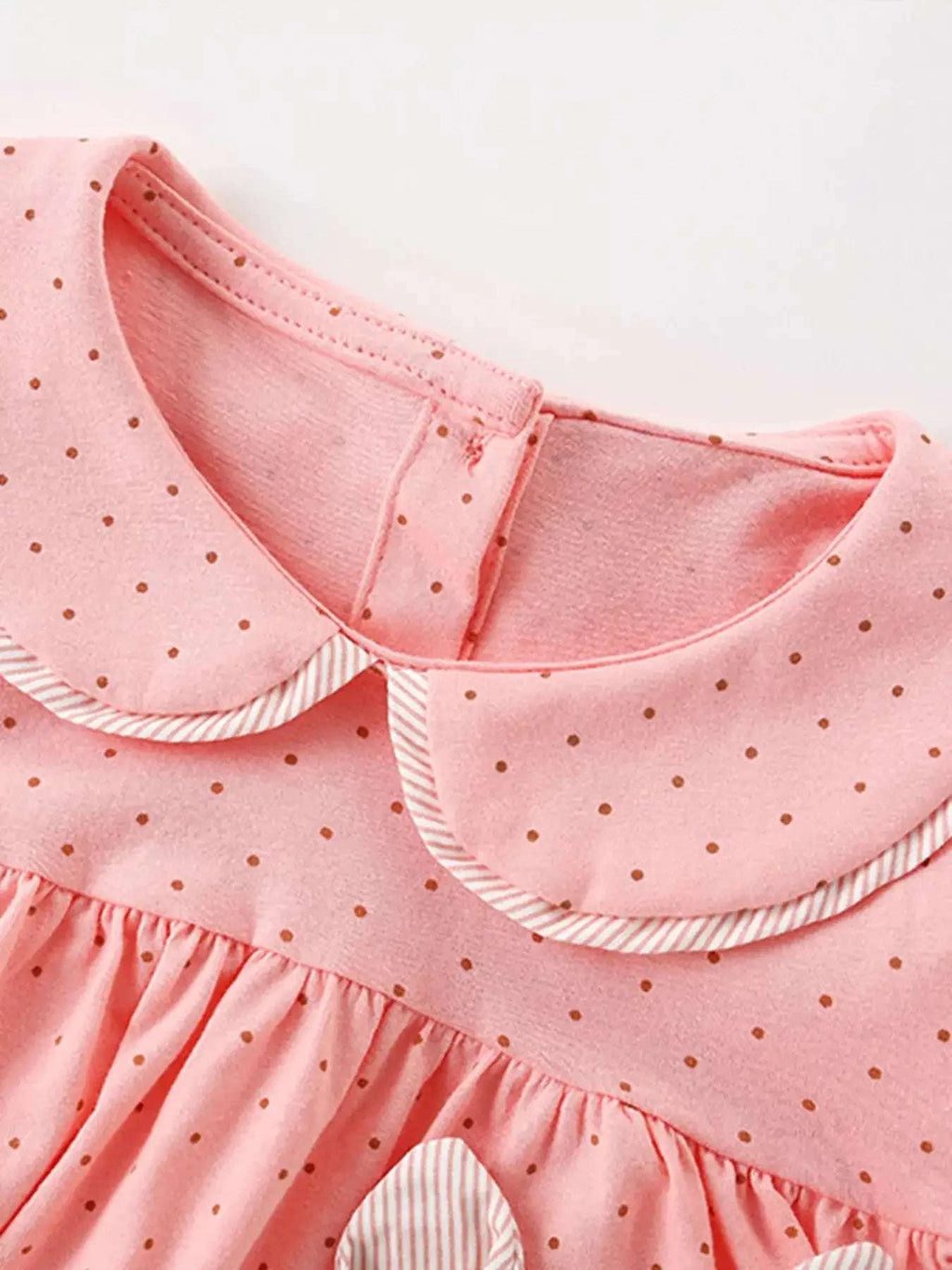 Dusty pink polka dot children’s top with ruffled collar and gathered waist