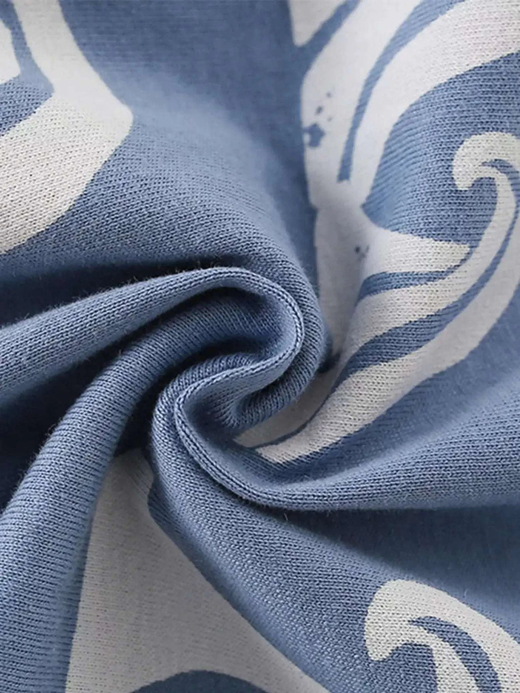 Dusty blue knit tee fabric with ocean wave pattern fold