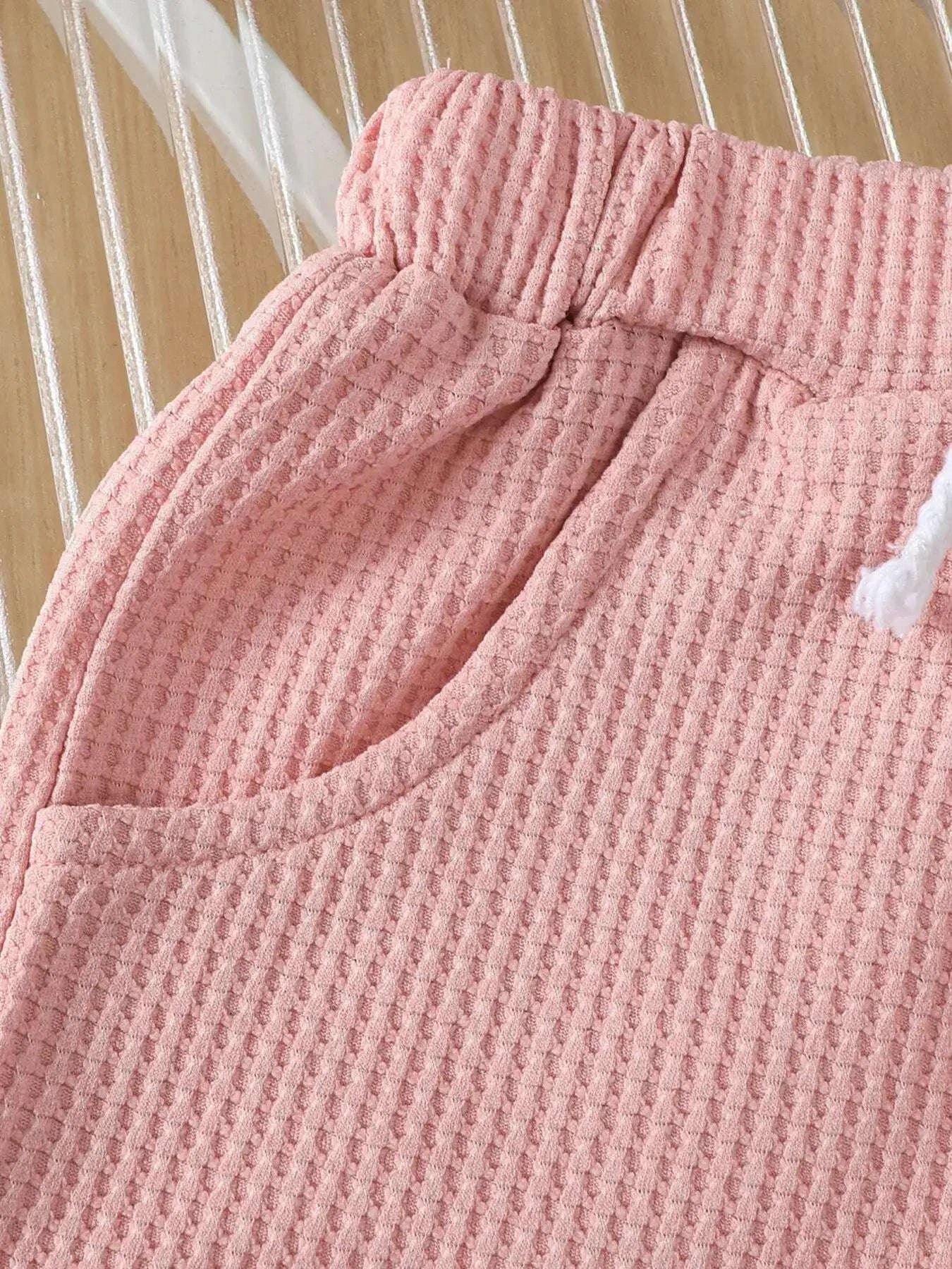 Pink waffle-knit shorts with elastic waist and gathered pleats