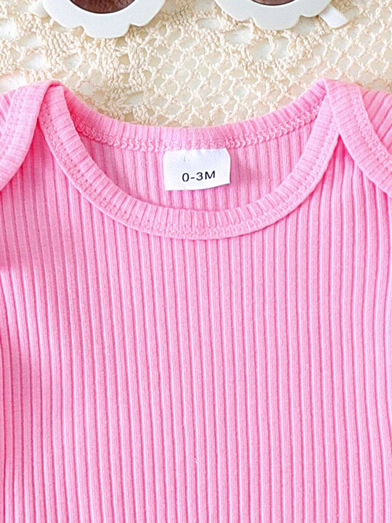 Pink ribbed knit top with ruffle trim and round neckline for baby