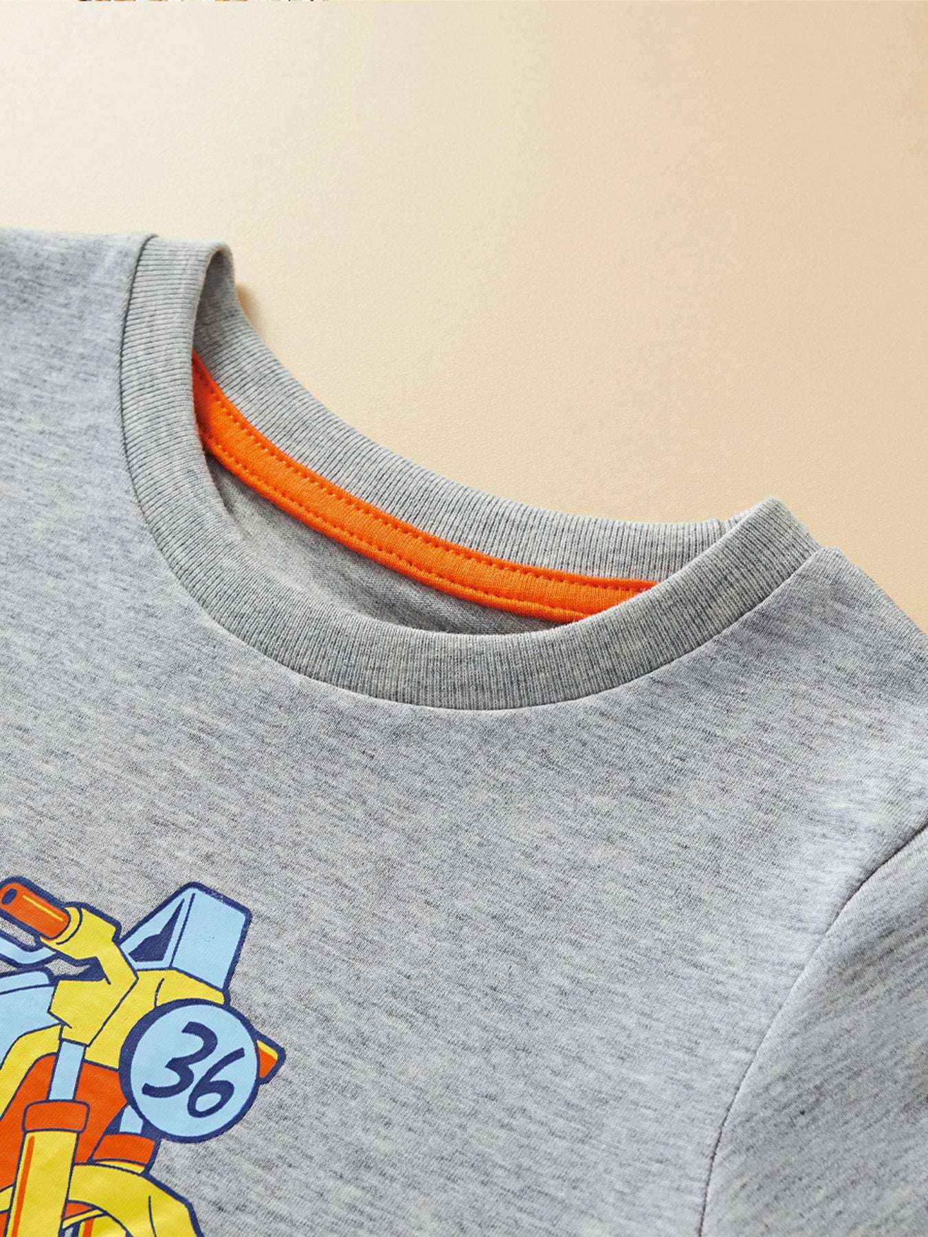 Light gray crew-neck T-shirt with orange ribbed collar and partial vehicle graphic
