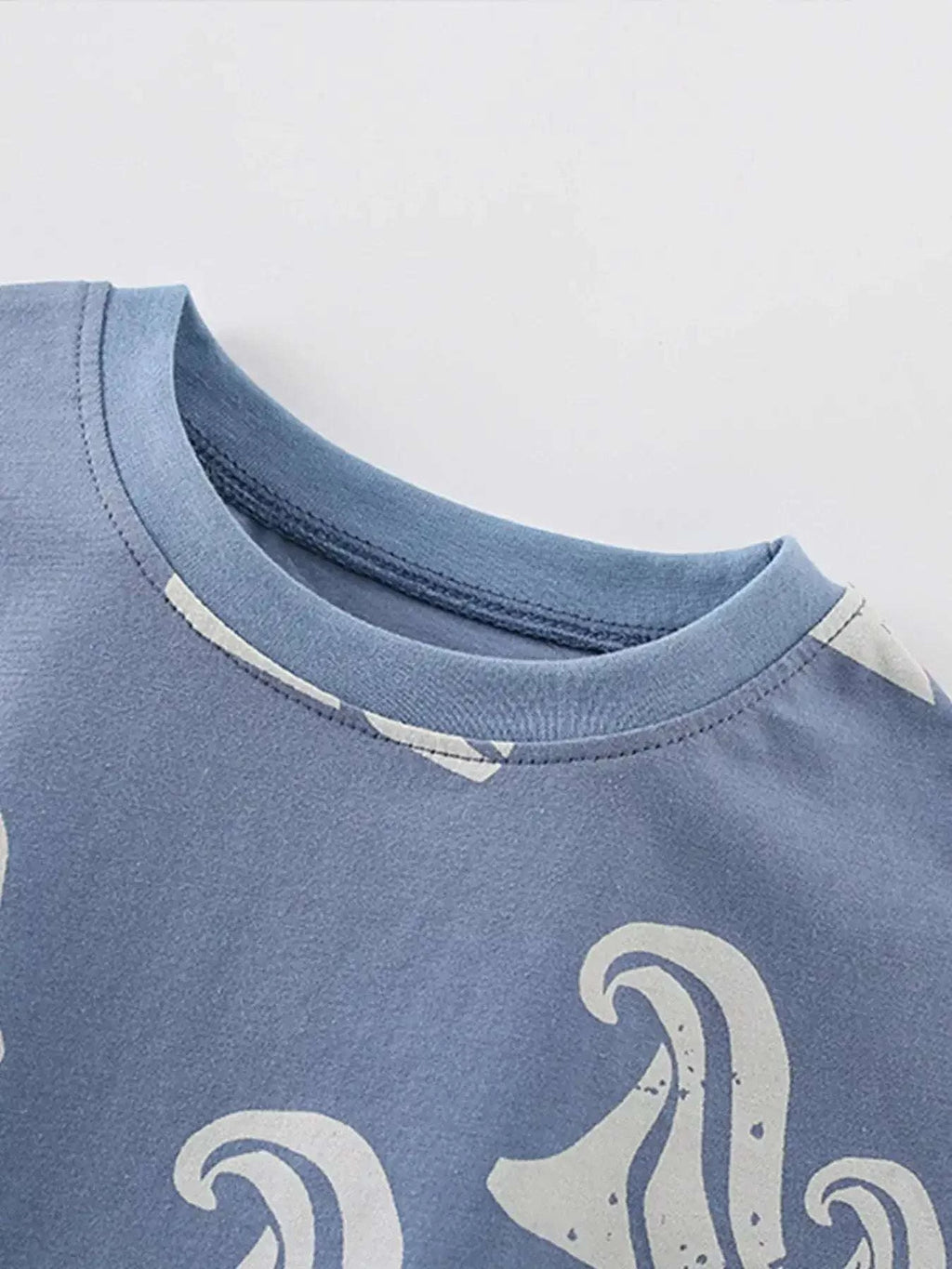Dusty blue children's tee with ocean wave print and round crew neckline