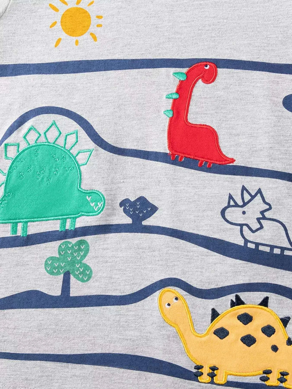 Light gray T-shirt front with colorful dinosaurs and sun over blue wave bands