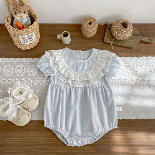 Light blue infant ruffle-front romper with short puff sleeves and lace trim bib
