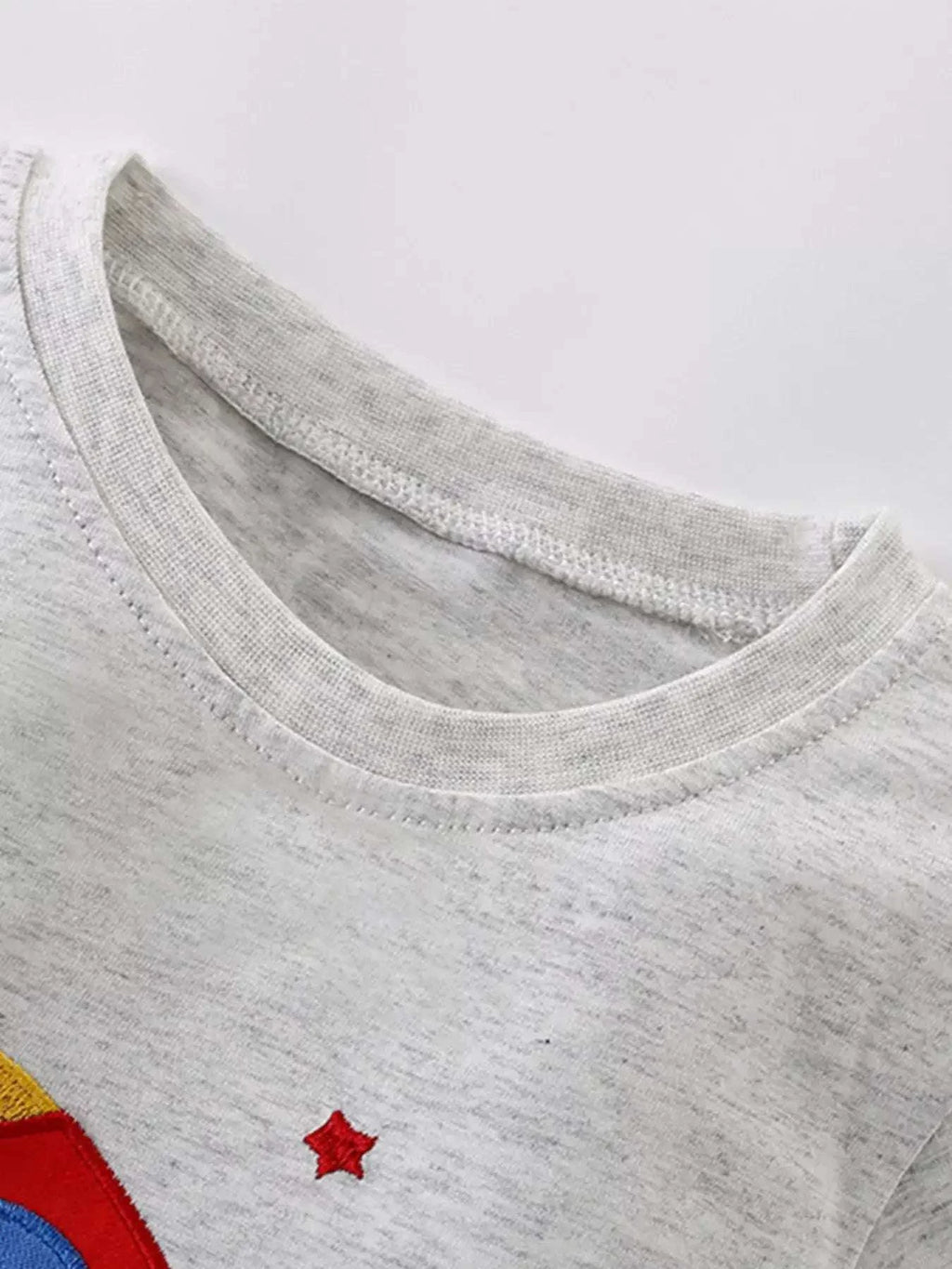 Light gray kids T-shirt neckline with small red star applique